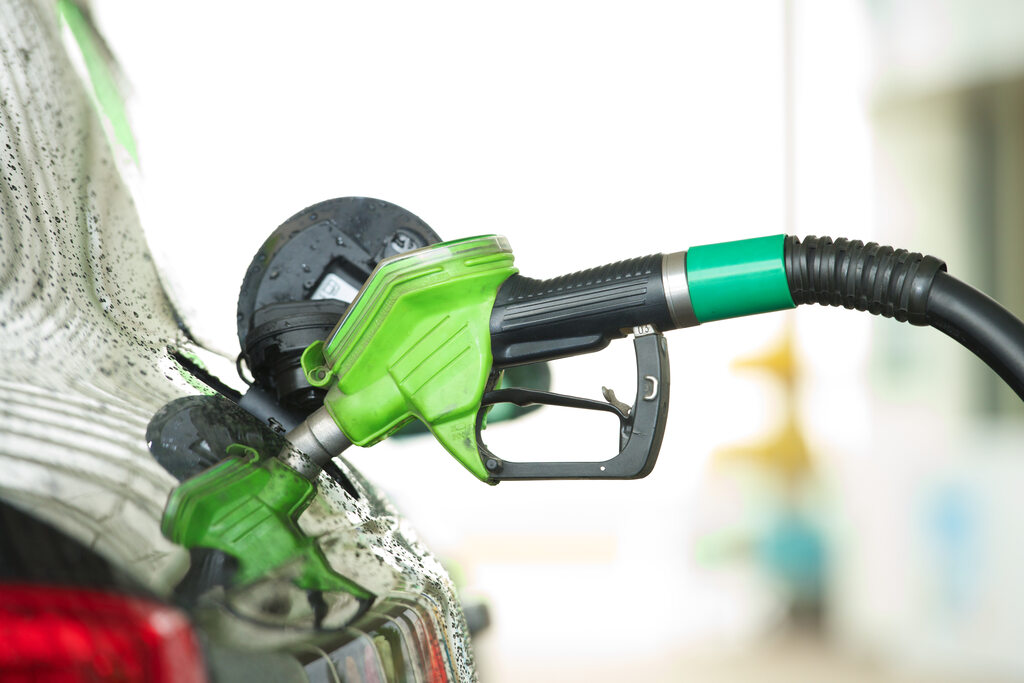 Bomba de combustível abastecendo carro com bico verde, simbolizando biocombustível B15.